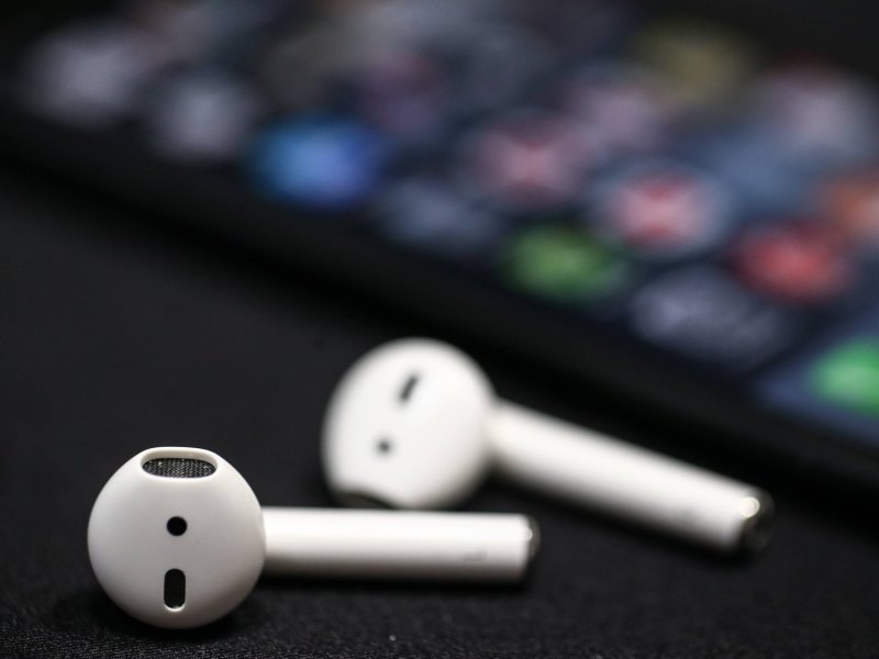 Apple AirPods liegen vor einem iPhone