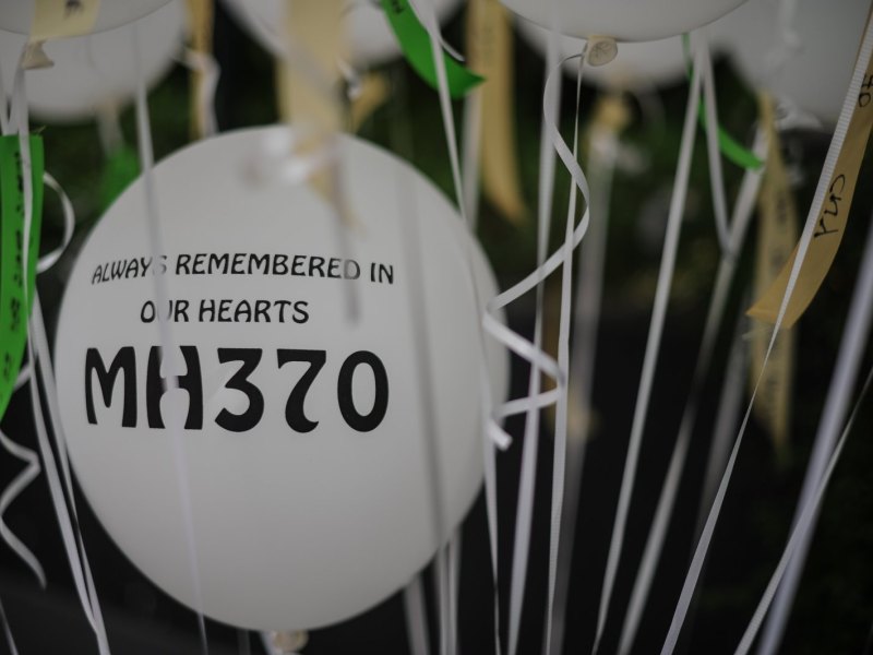 Auf einem Ballon steht "Always remembered in our hearts: MH370".