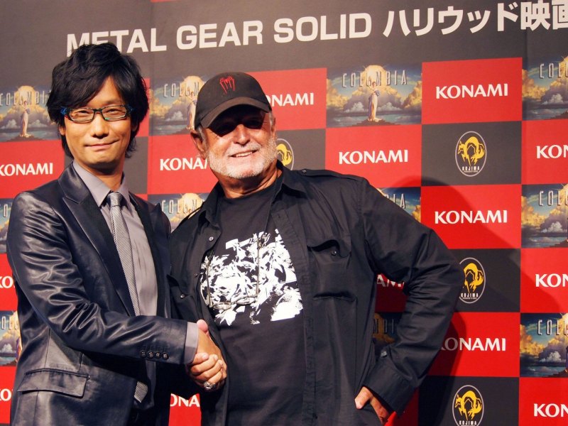 Kojima schüttelt Hand vor Konami Banner