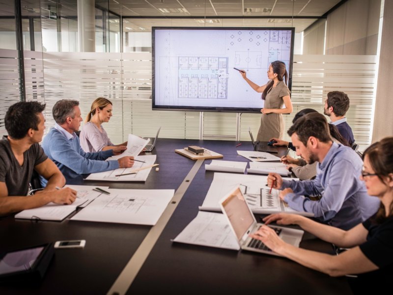 Frau präsentiert in einem Meeting.