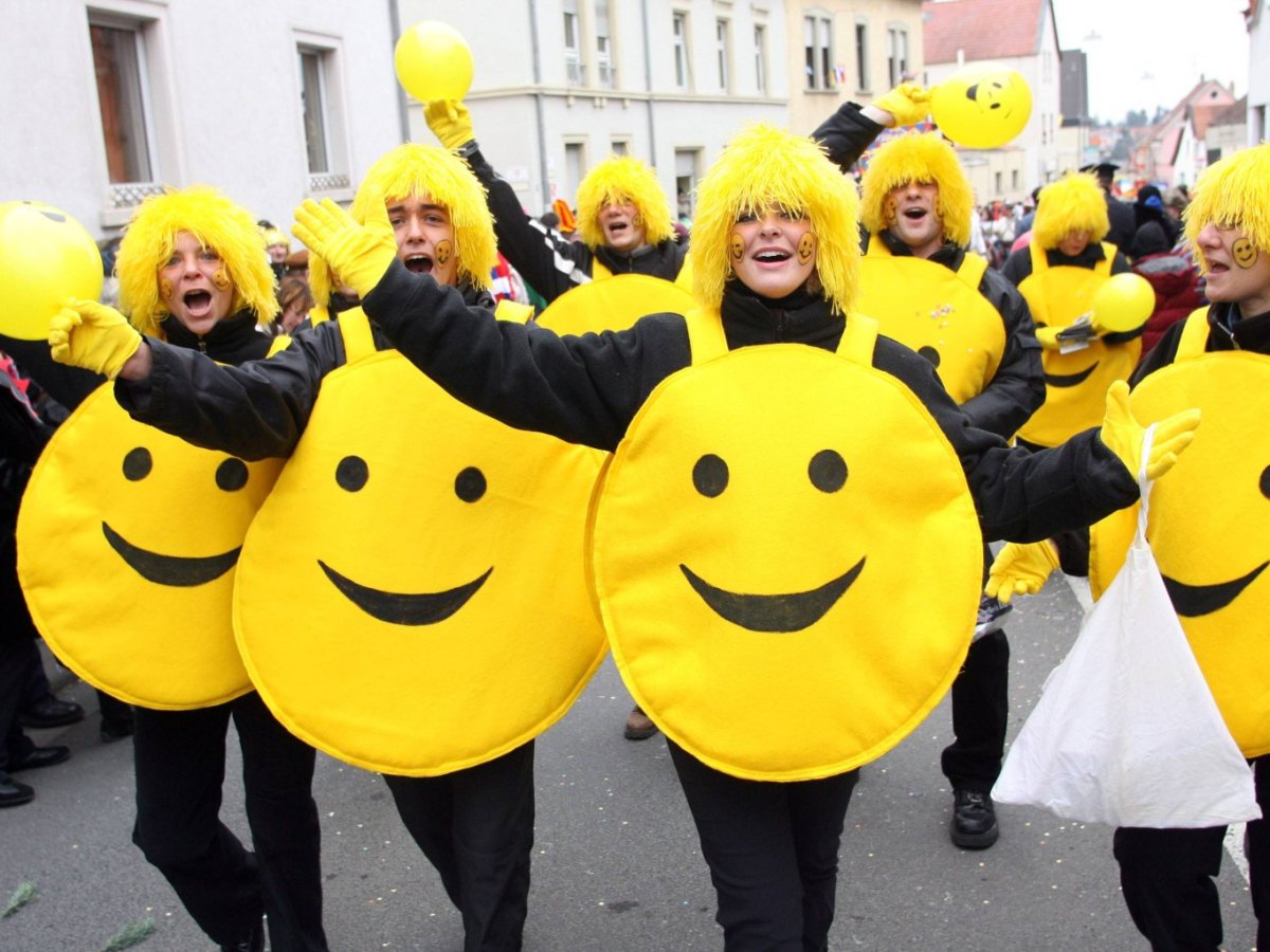 Personen sind als Smiley verkleidet