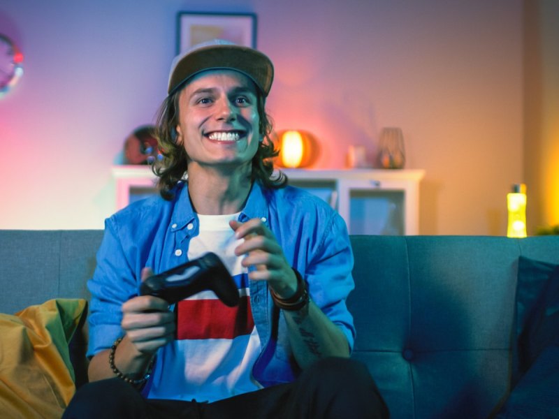 Grinsender Mann mit PS4-Controller