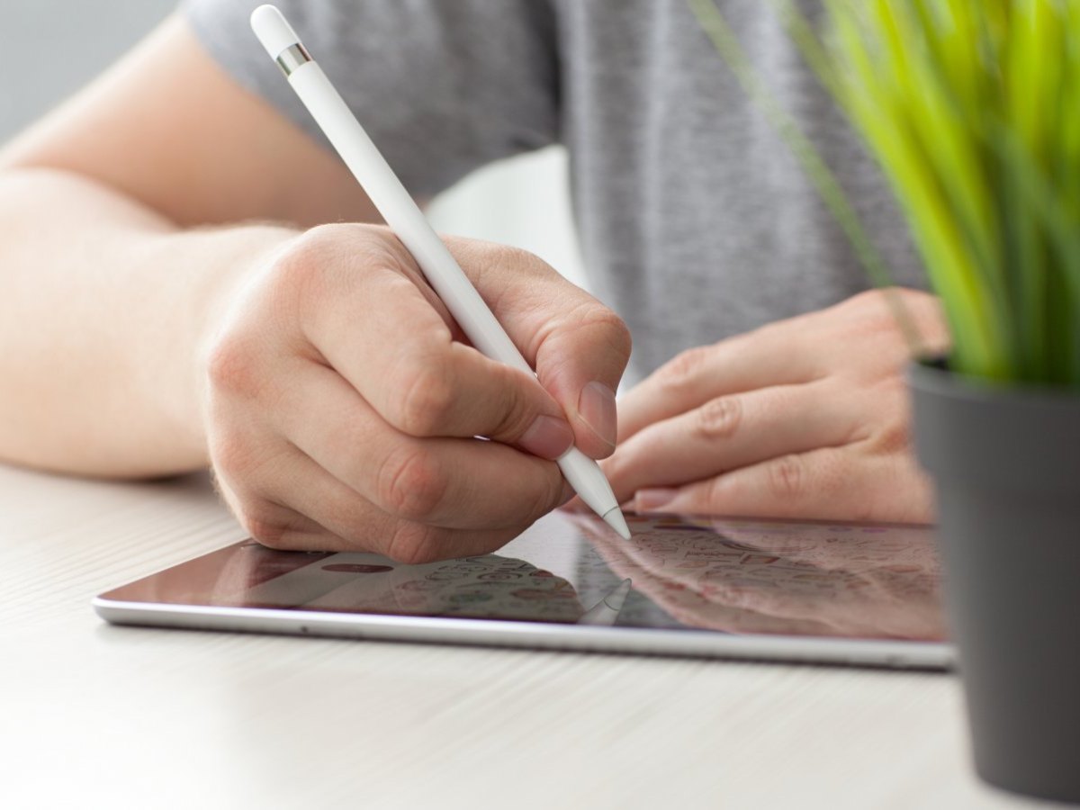 Person schreibt auf iPad