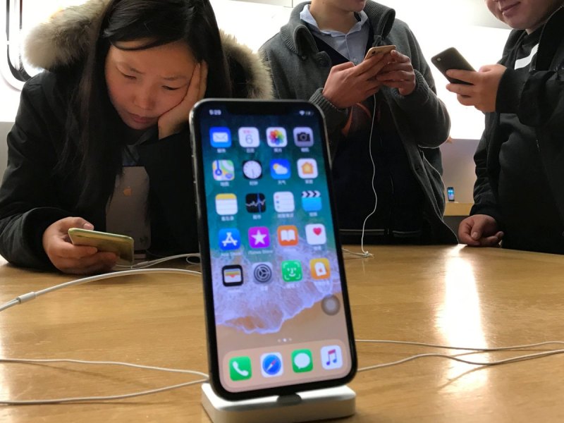 iPhone X mit Menschen im Hintergrund