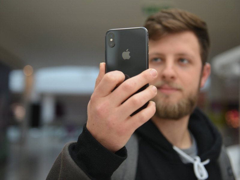 Ein Mann entsperrt sein Smartphone mit dem Gesicht.