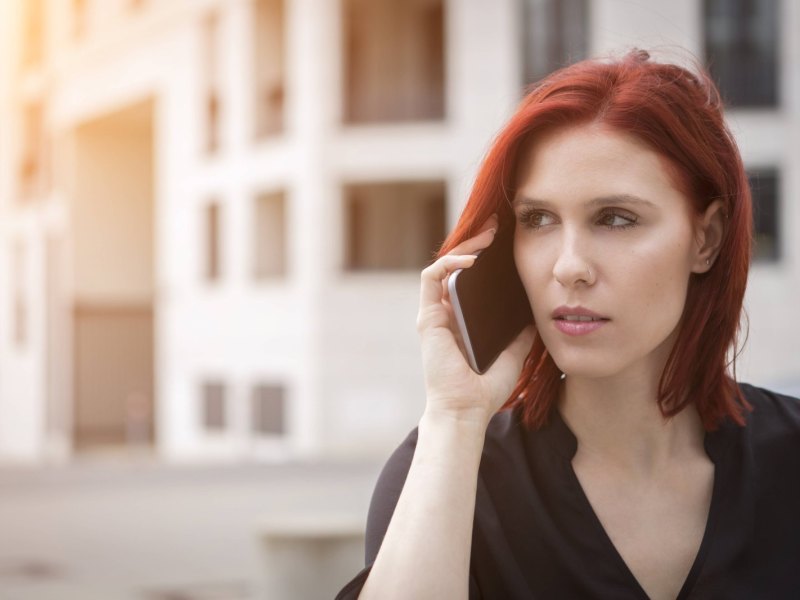 Junge Frau hat das Handy am Ohr und telefoniert