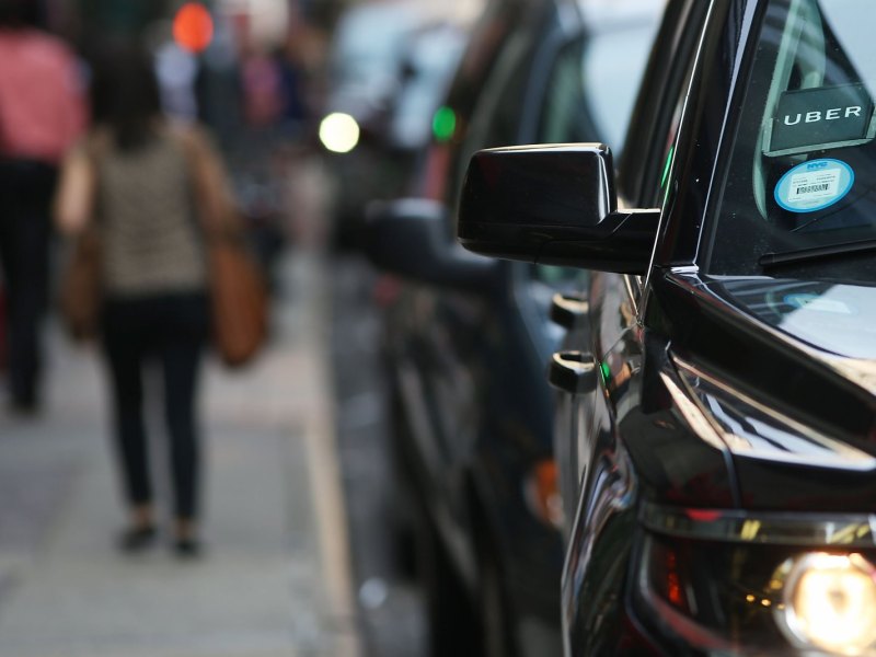 Geparktes Auto mit "Uber"-Logo auf der Windschutzscheibe