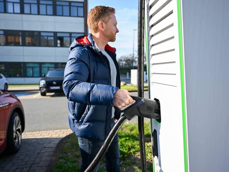 Mann lädt Auto an Wallbox