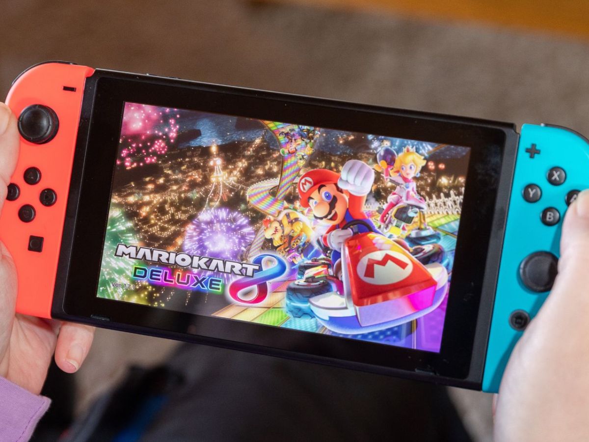 Person hält Nintendo Switch mit "Super Mario Kart 8 Deluxe".