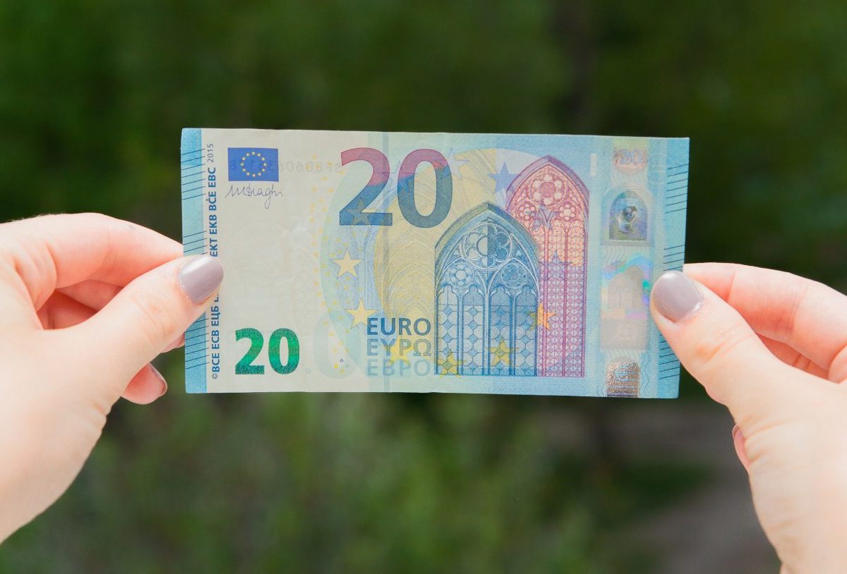 Frau hält einen 20-Euro-Schein in der Hand.