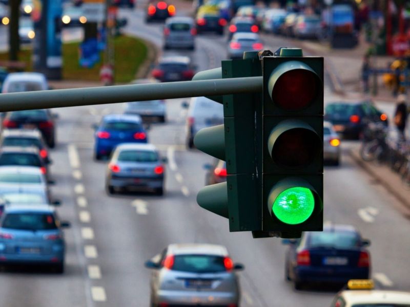 Grüne Ampel über einer stark befahrenen Straße