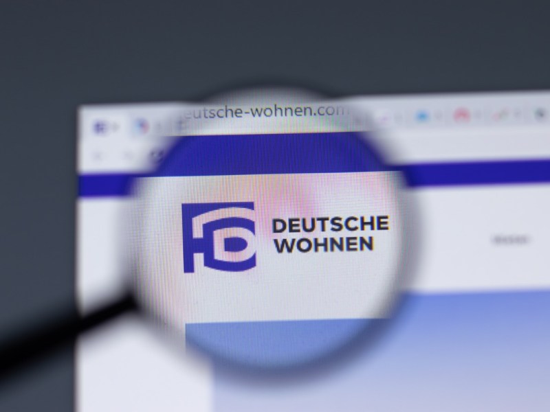 Logo der Deutsche Wohnen unter einer Lupe