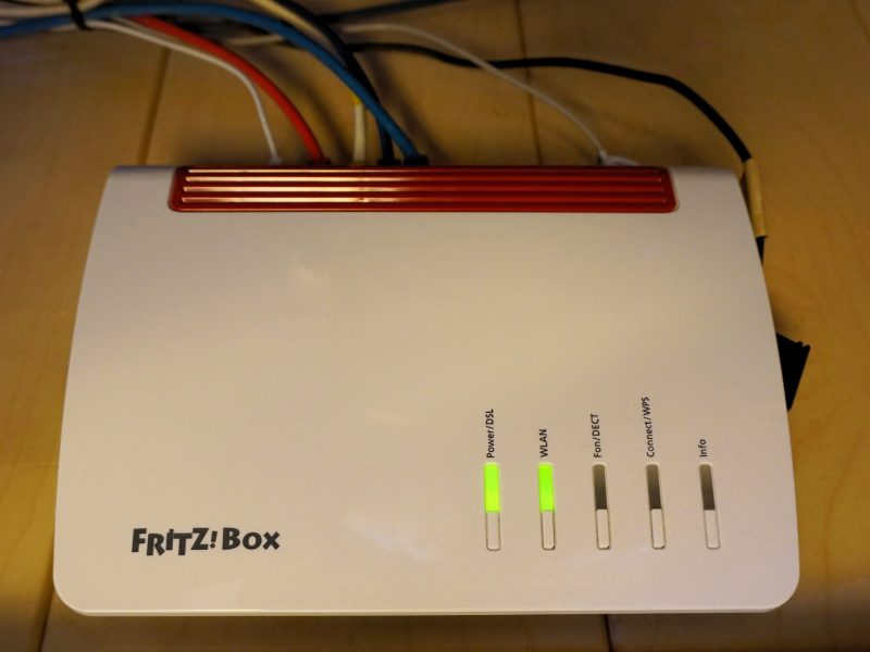 FritzBox-Router auf einem braunen Tisch.