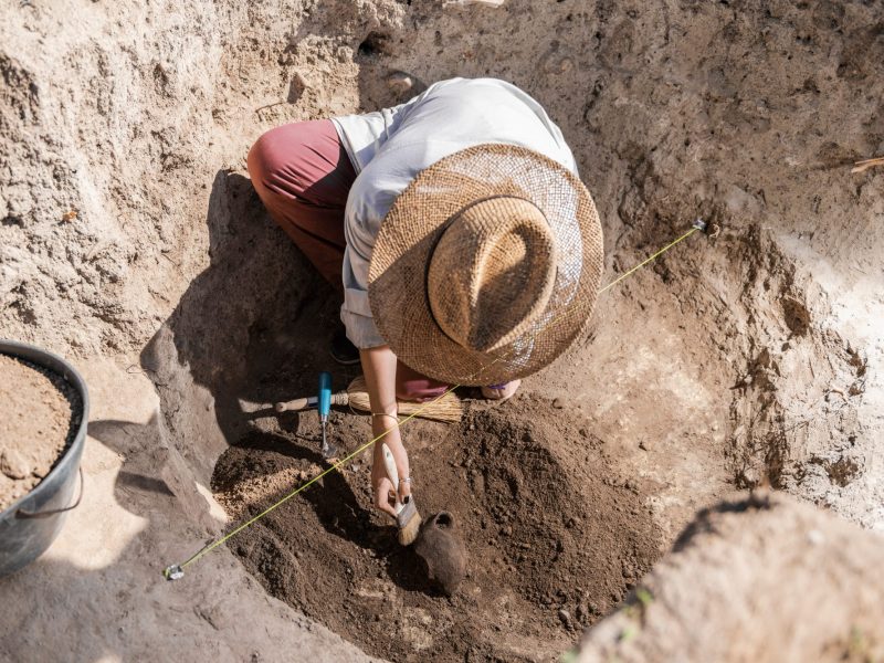 Mensch arbeitet an einem archäologischen Fund.