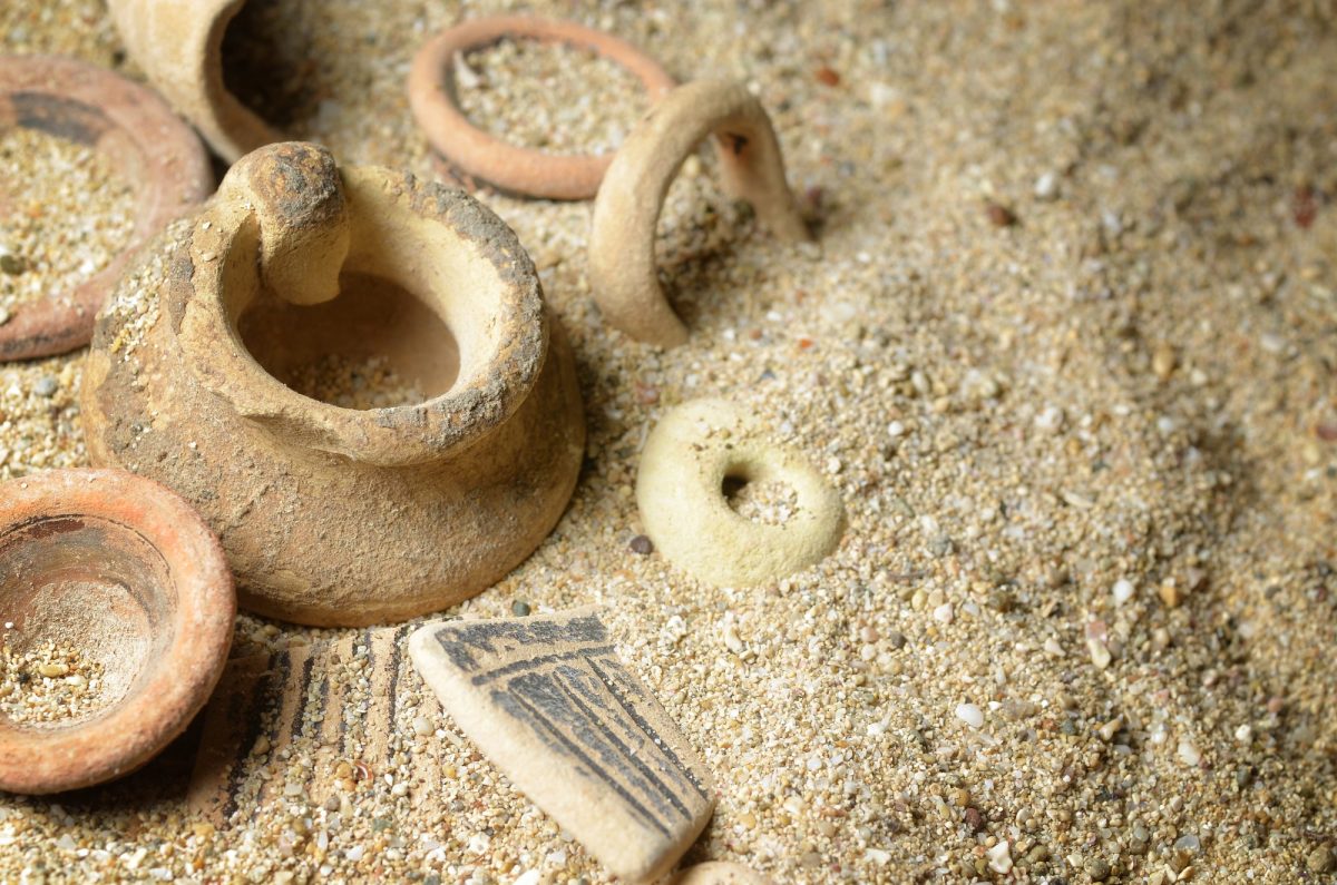 Archäologischer Fund aus Keramik im Sand.