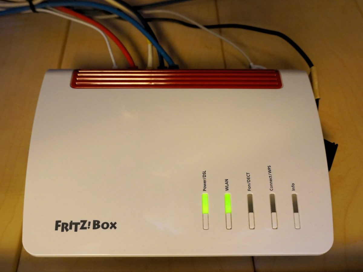Ansicht eines FritzBox-Routers auf braunem Tisch.