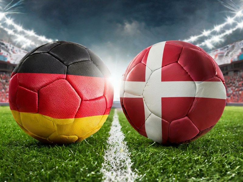 Zwei Fussbälle in den Landesfarben von Deutschland und Dänemark für die EM 2024