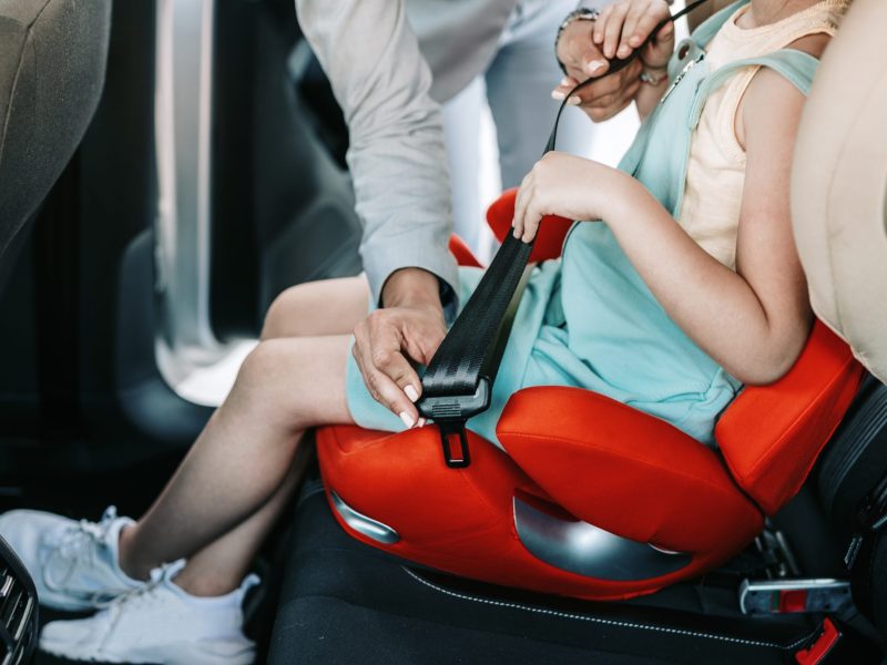 Kind sitzt in einem Kindersitz im Auto.