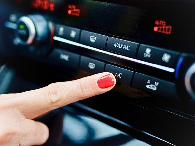 Frau bedient Klimaanlage im Auto