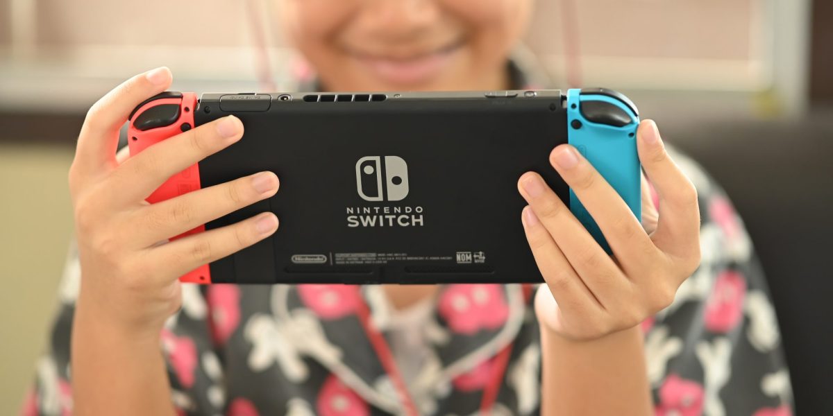 Person hält Nintendo Switch Konsole in den Händen.