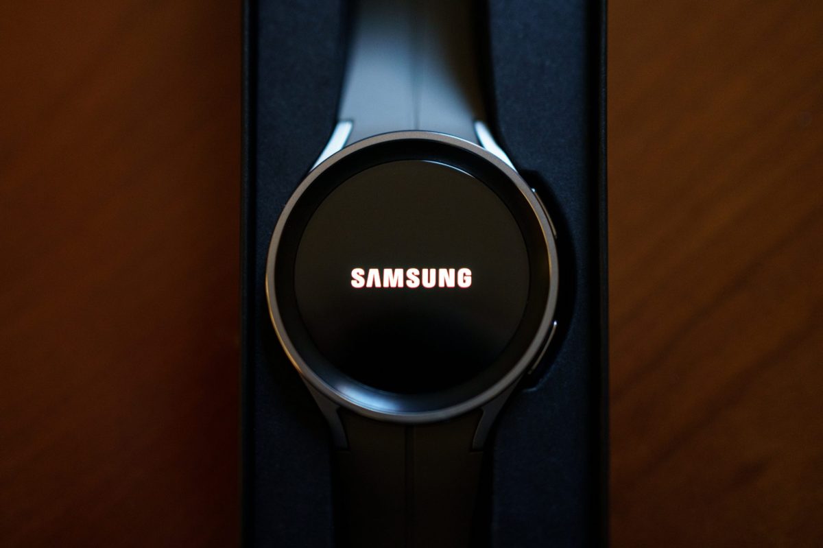 Eine Samsung Galaxy Watch5 liegt auf einem dunklen Hintergrund. Auf dem Display steht "Samsung" geschrieben.