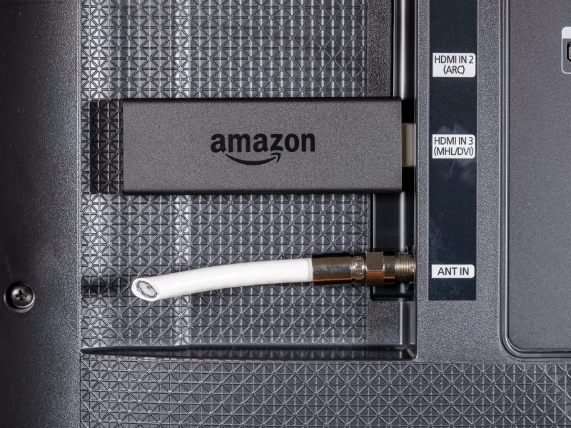 Amazon Fire Tv Stick ist an einem HDMI-Anschluss an der Rückseite eines Fernsehers befestigt.