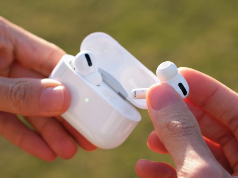 Person hält Apple Airpod aus dem Lade-Case.