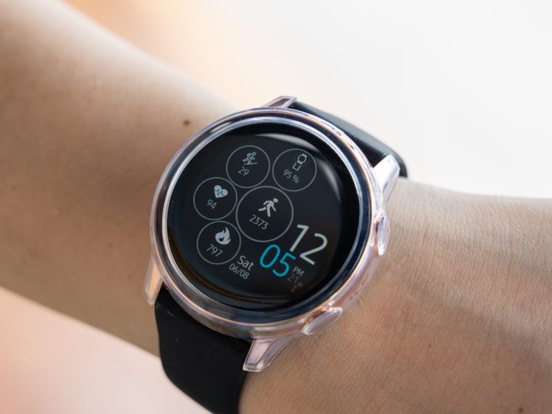 Samsung Galaxy Watch am Handgelenk einer Person. Auf dem Display werden verschiedene Funktionen zur Gesundheits-Überwachung angezeigt.