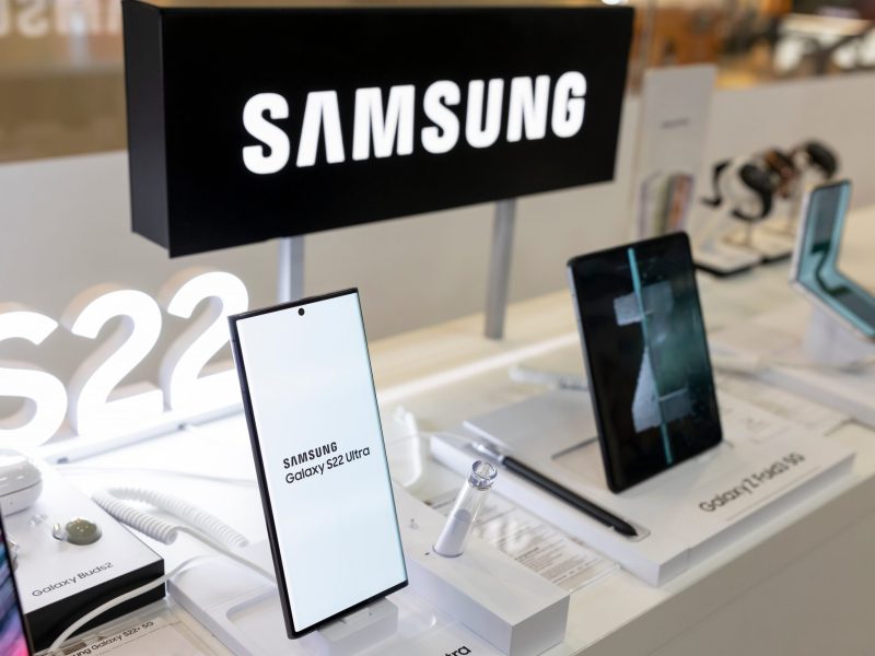 Verschiedene Samsung Galaxy-Handys werden in einer Auslage präsentiert. Darüber steht das Samsung-Logo.