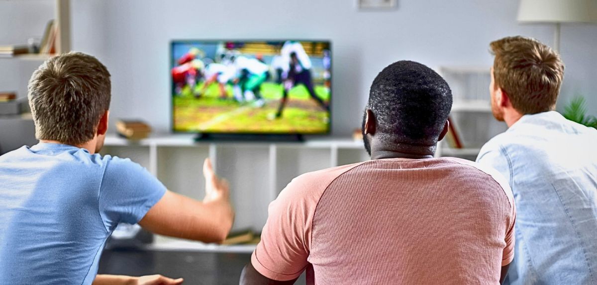 Drei Männer schauen Fußball im TV