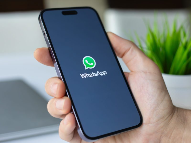WhatsApp-Logo auf einem Handydisplay.