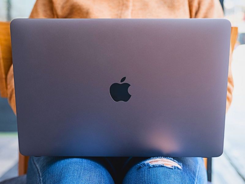 MacBook von Apple auf dem Schoß einer Frau.