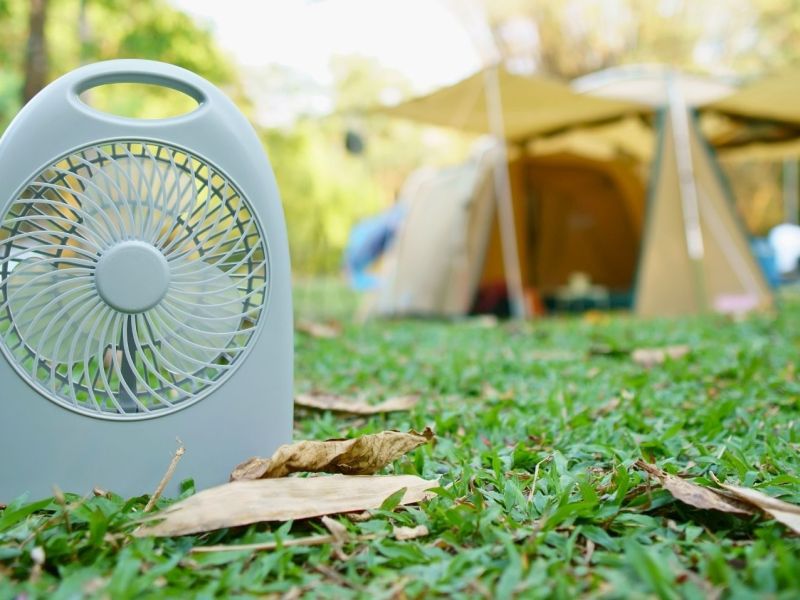 Camping-Ventilator mit Zelt im Hintergrund.