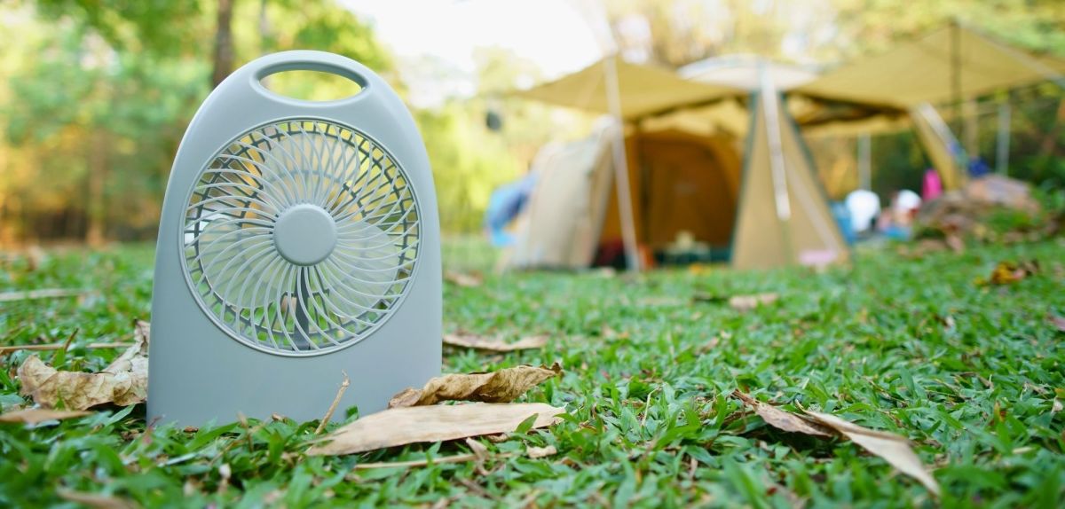 Camping-Ventilator mit Zelt im Hintergrund.