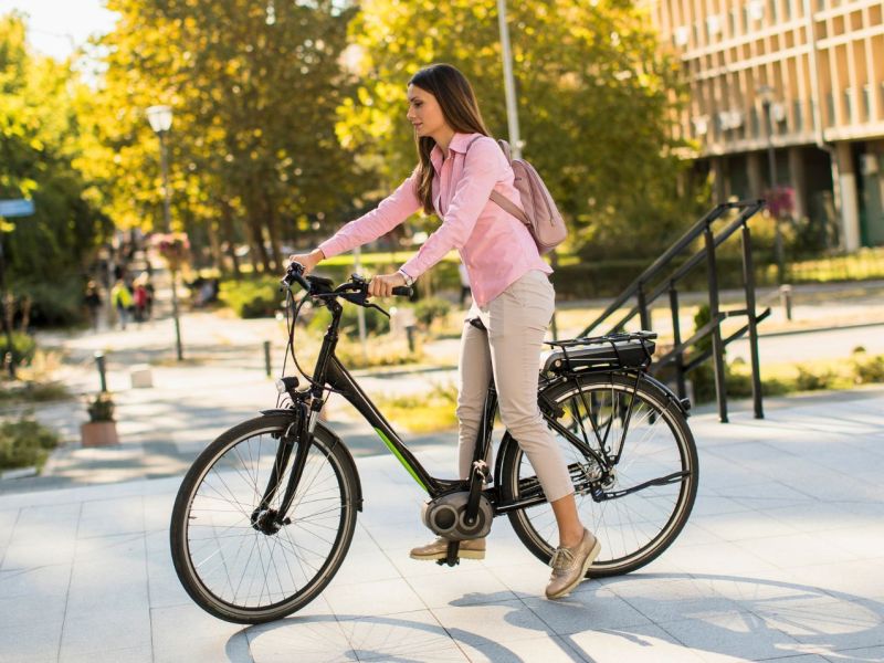 Frau fährt E-Bike in der Stadt