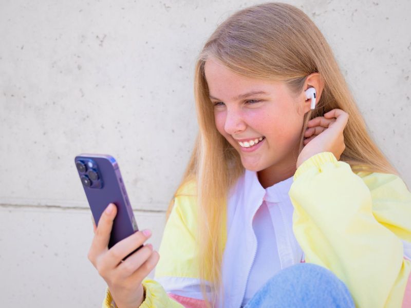 Mädchen nutzt iPhone mit AirPods