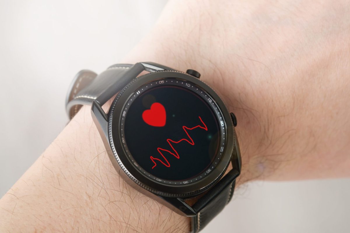 Eine Person trägt eine Samsung Galaxy Watch am Handgelenk, Auf dem Display wird der Puls der Person gemessen.