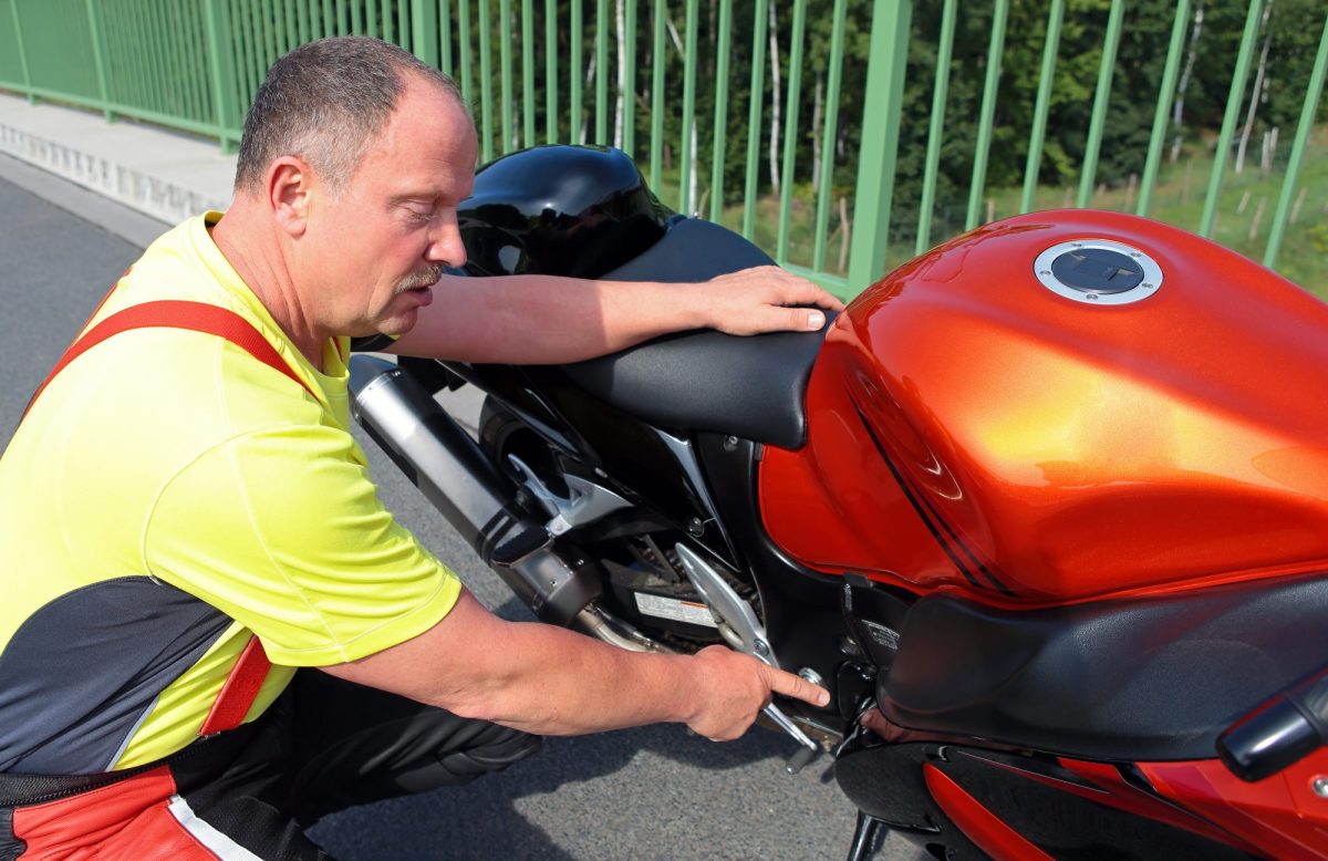 Mann führt den TÜV beim Motorrad durch.