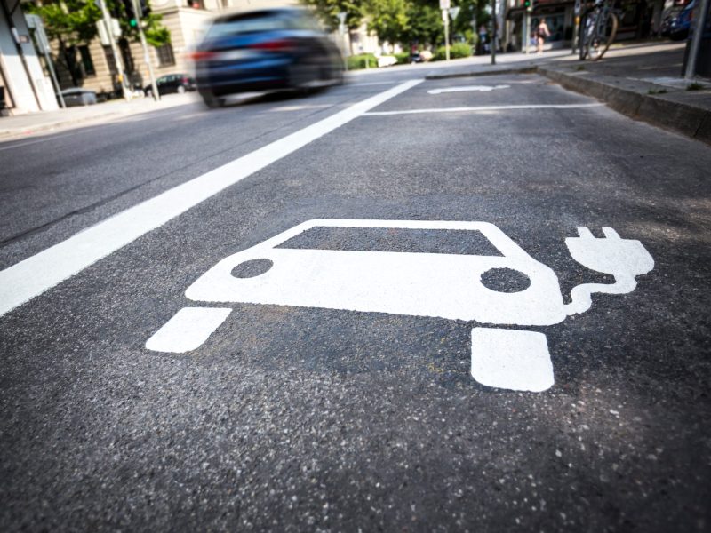 Zeichen für ein Parkplatz zum Elektroauto laden am Straßenrand.