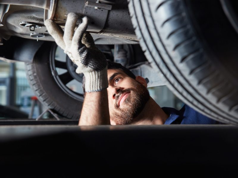 Mechaniker bei einer TÜV-Kontrolle am Wohnwagen.