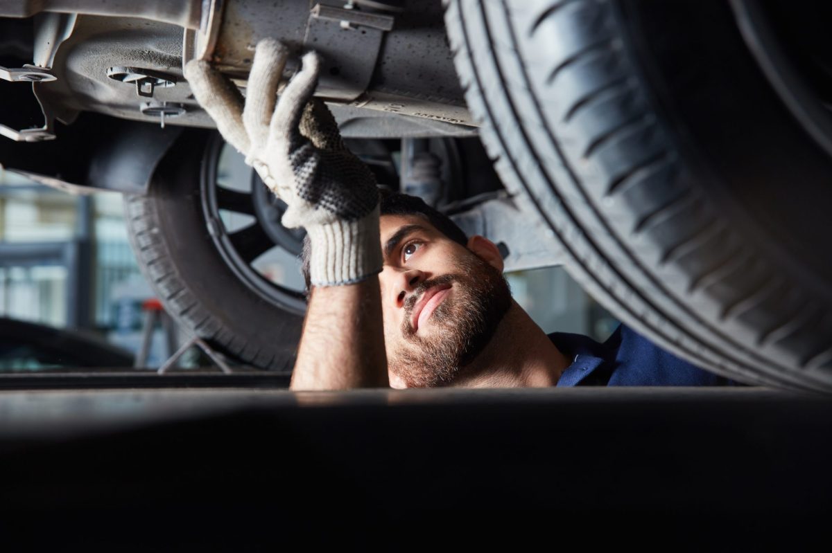 Mechaniker bei einer TÜV-Kontrolle am Wohnwagen.