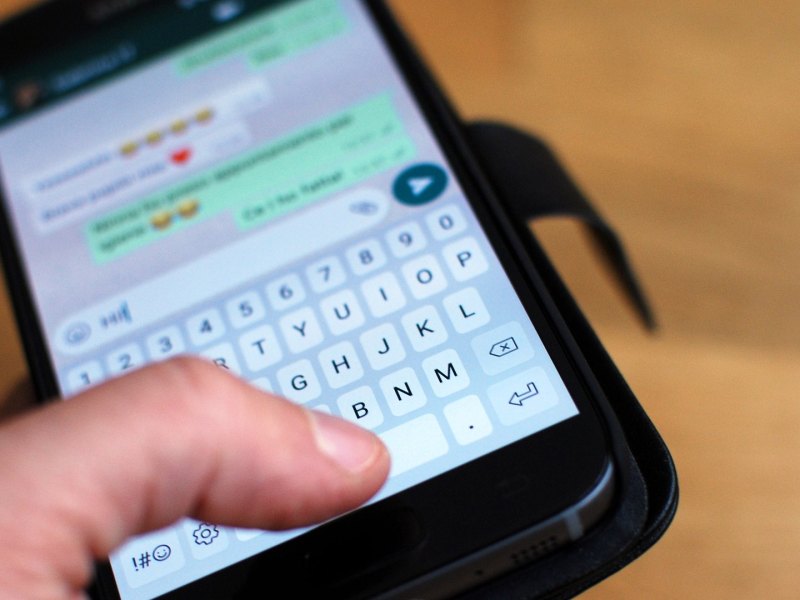 Whatsapp auf dem Handy und eine Hand.