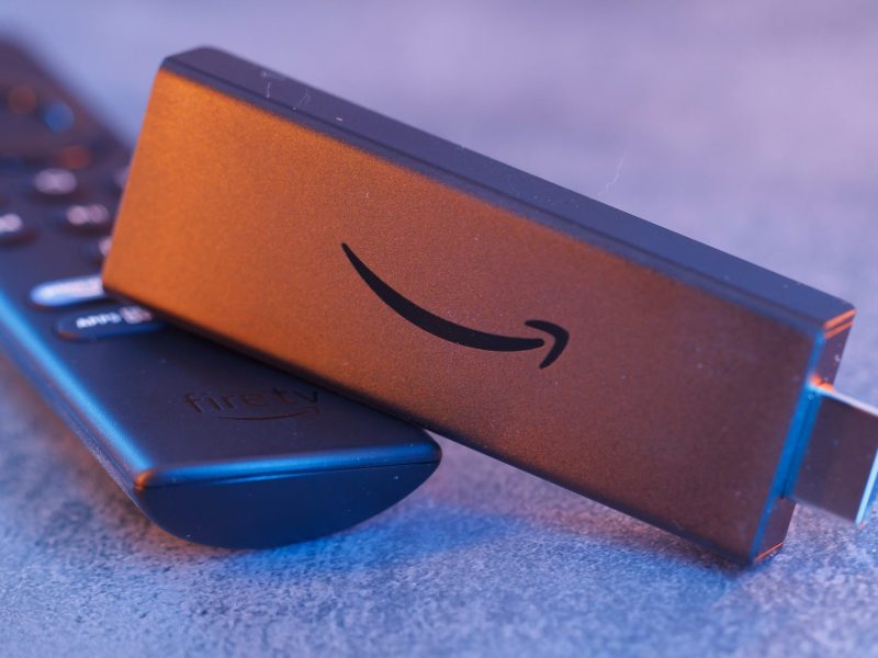 Amazon Fire TV Stick liegt neben einer Amazon Fire TV Fernbedienung.