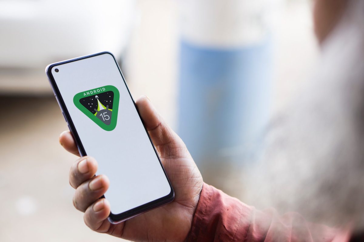 Eine Person hält ein Handy in der Hand. Auf dem Display wird das Android 15 Logo angezeigt.