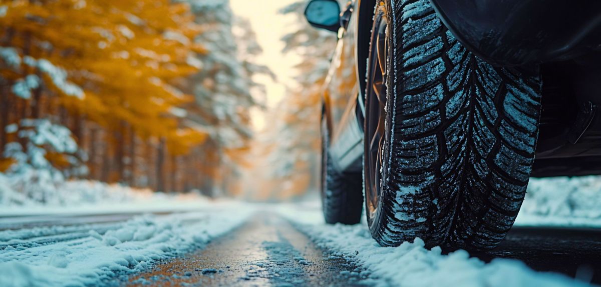 Auto fährt auf einer verschneiten Straße.