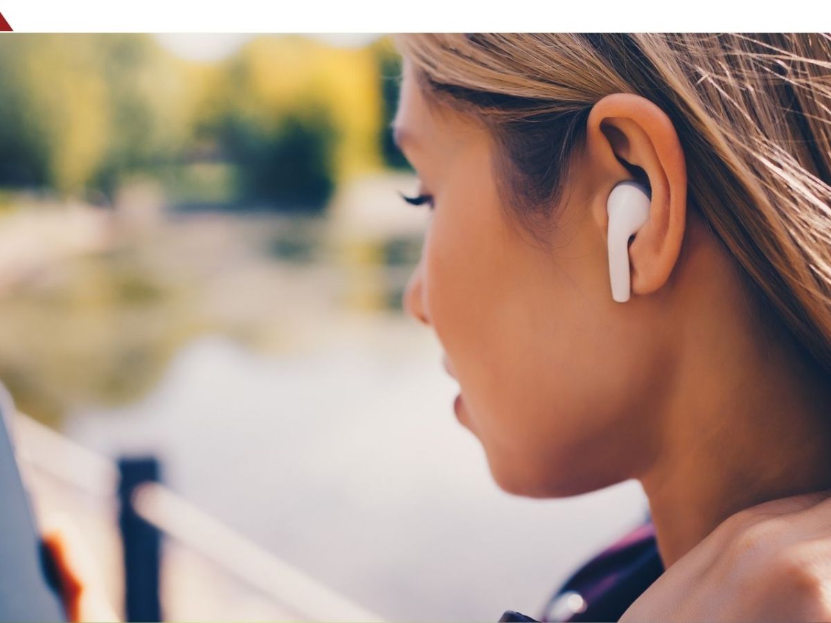 Frau hört Musik über Bluetooth-Kopfhörer.