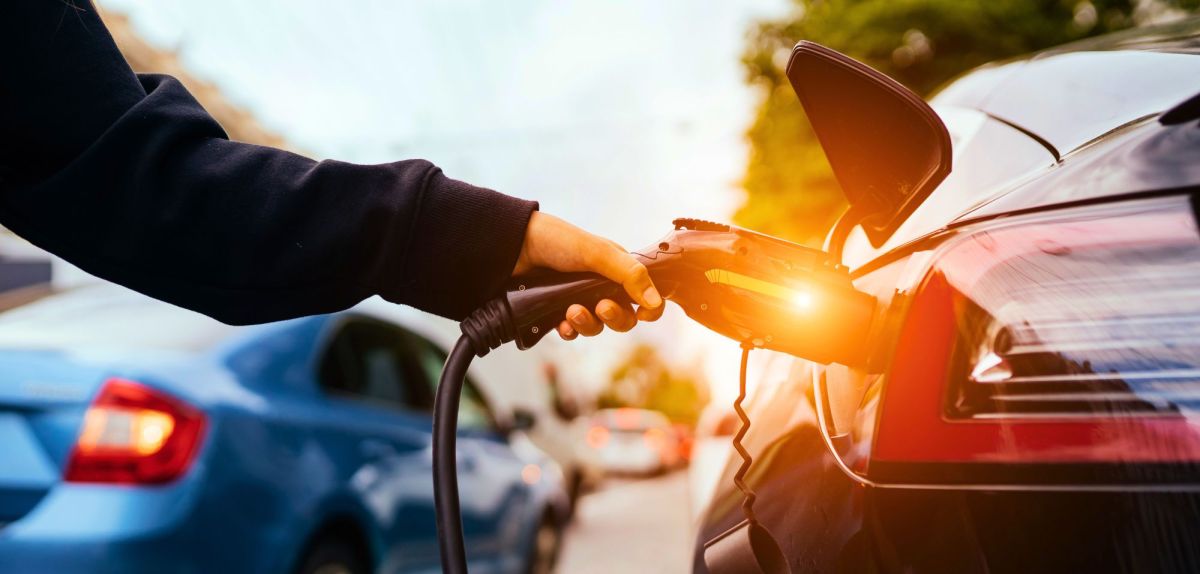 Person lÃ¤dt ein Elektroauto