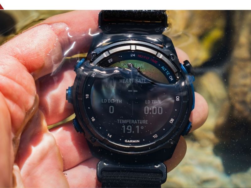 Person hält eine Garmin-Smartwatch ins Wasser.