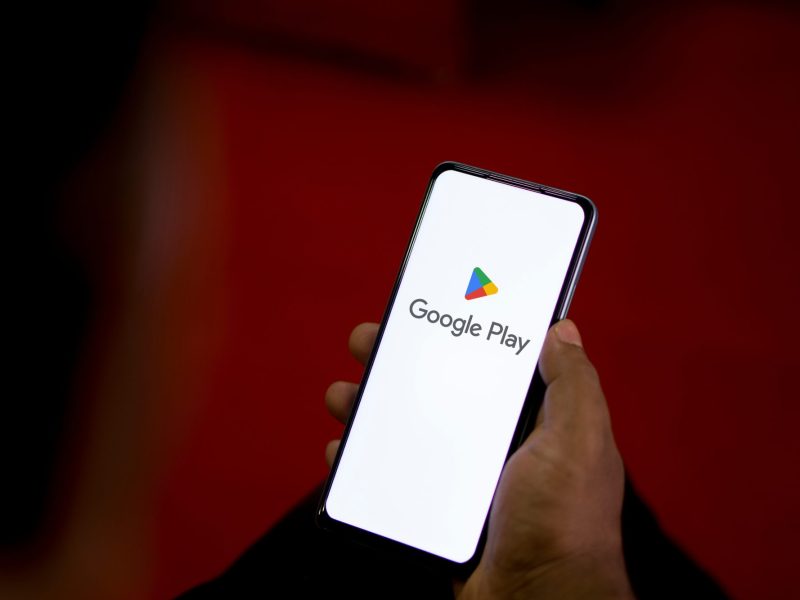 Person hält ein Handy in der Hand. Auf dem Display wird der Google Play Store angezeigt.