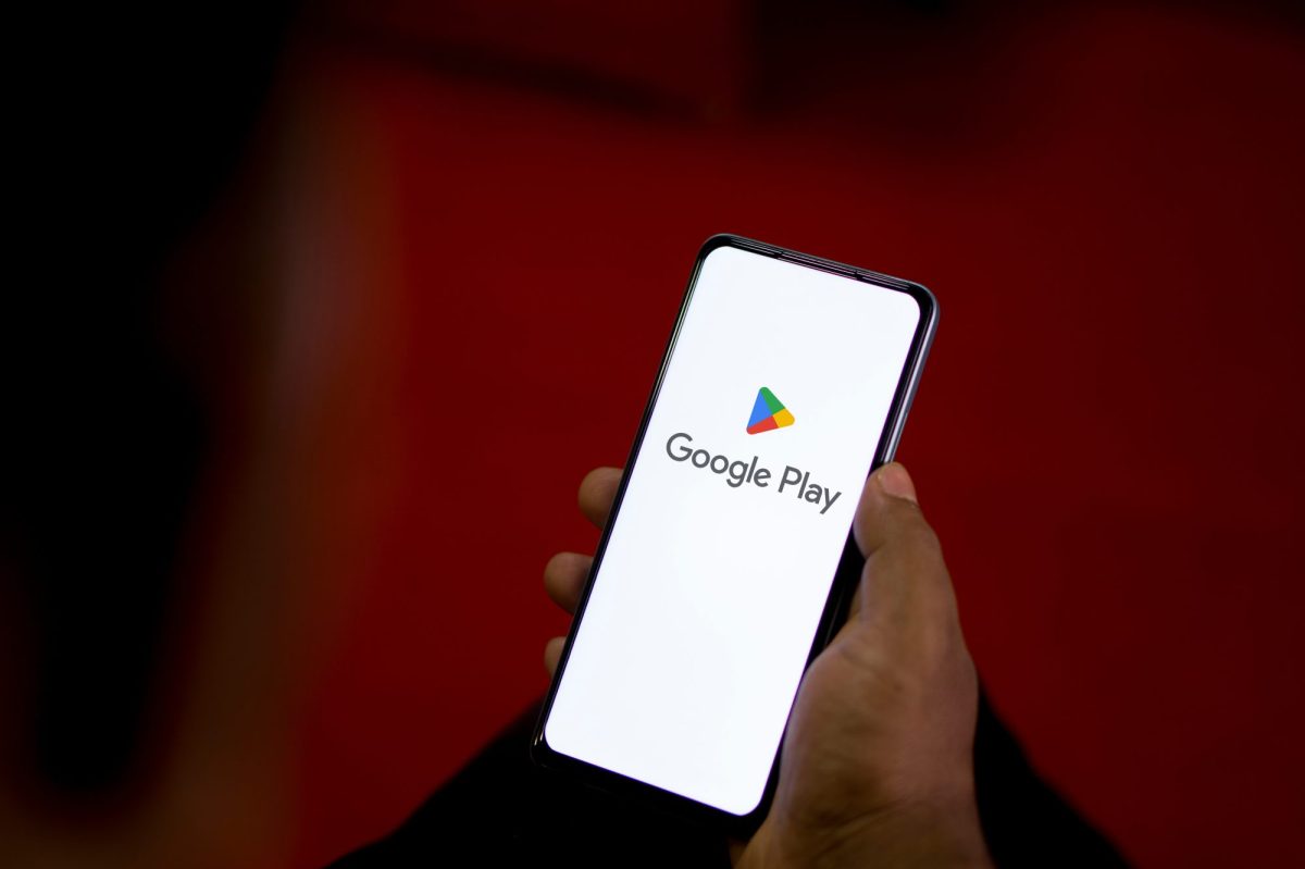 Person hält ein Handy in der Hand. Auf dem Display wird der Google Play Store angezeigt.